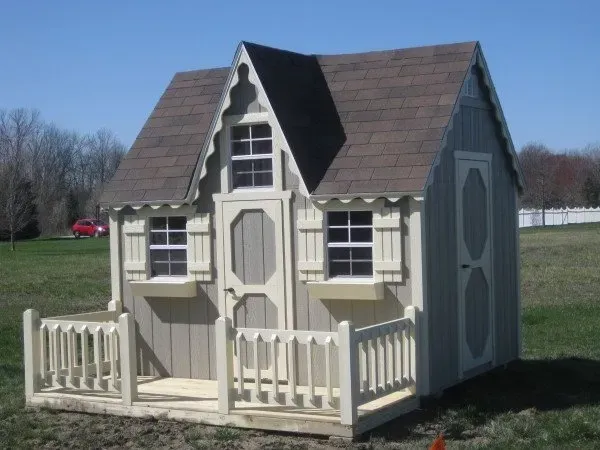 A small playhouse with a porch and shutters