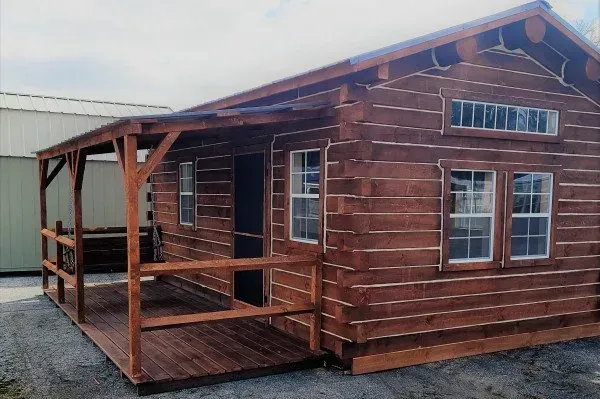 A small log cabin with a porch and windows