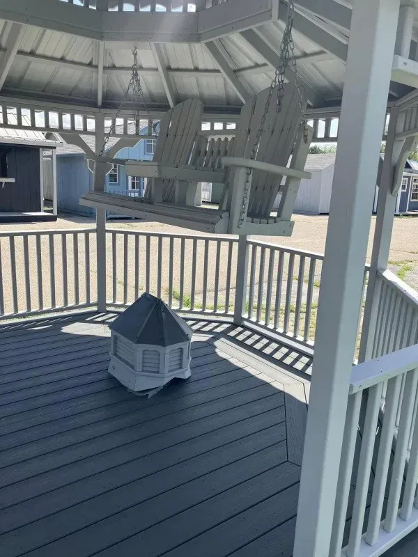 A gazebo with swings and a fire pit on the deck