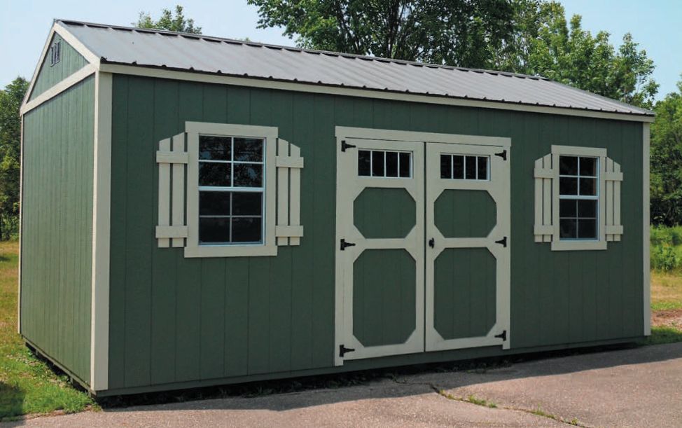 A green shed with white doors and windows