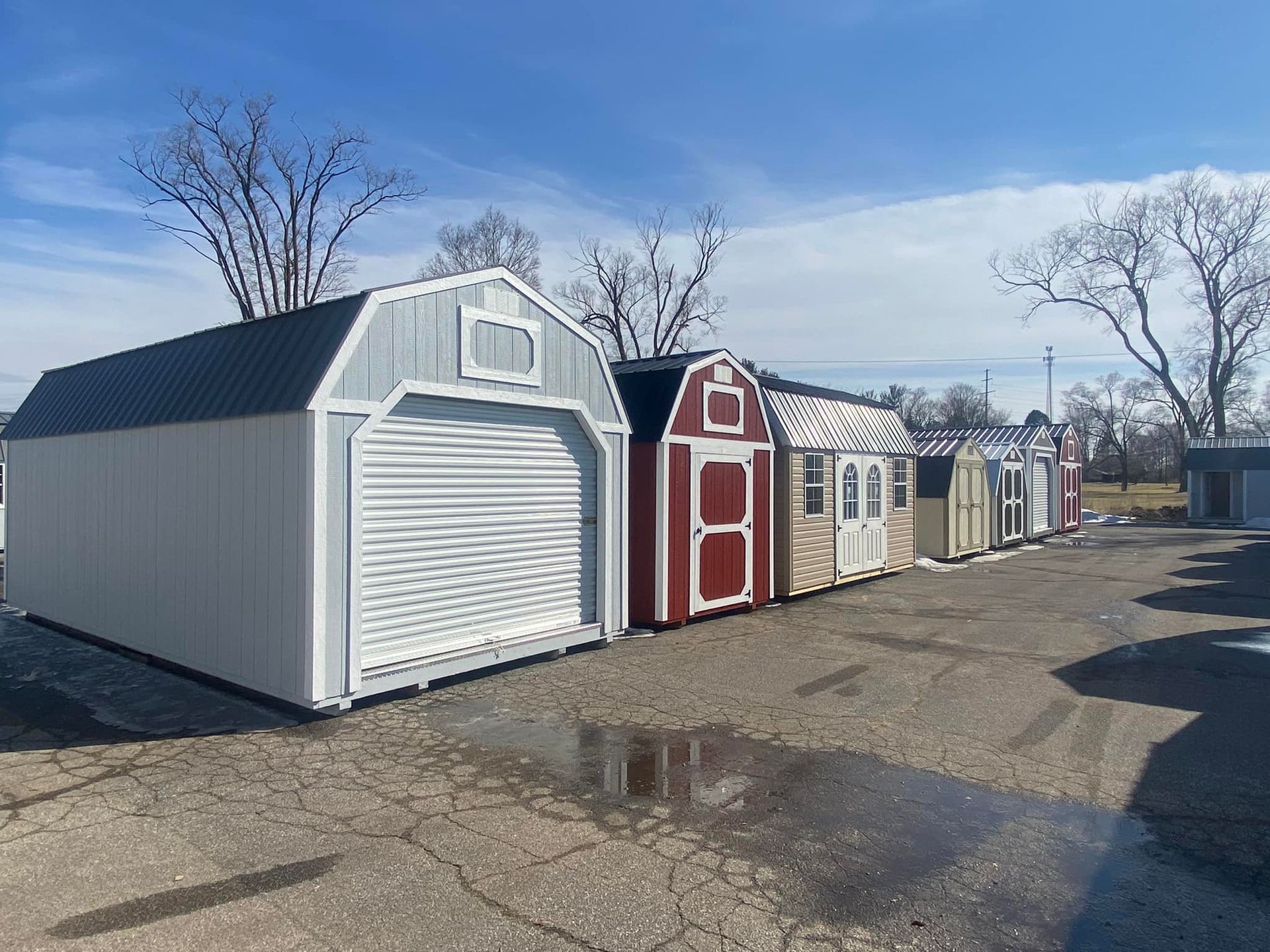A row of sheds are lined up in a parking lot.