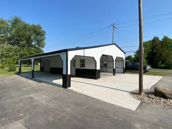 A white and black garage with a car parked in front of it