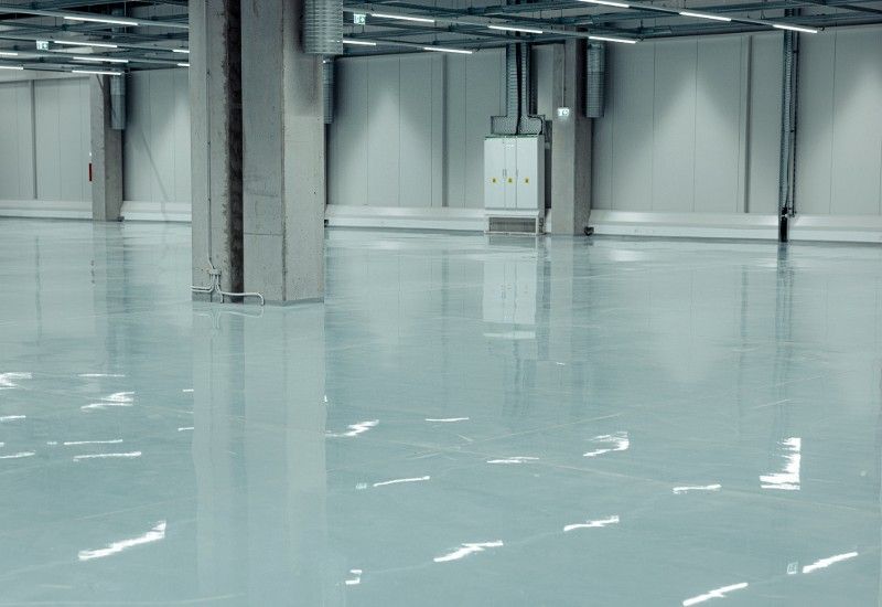 A large empty warehouse with a shiny floor