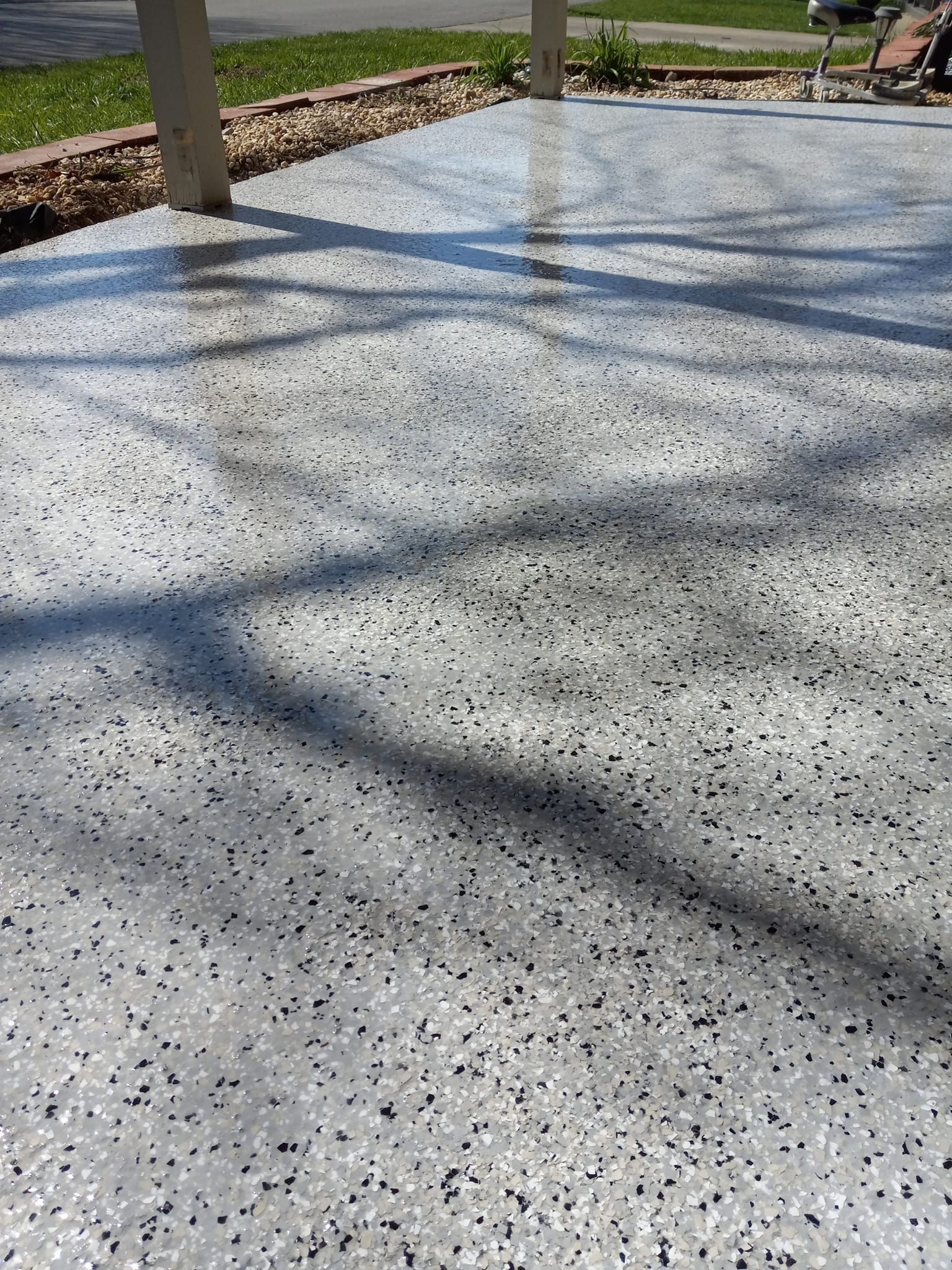 A concrete driveway with a lot of small stones on it.