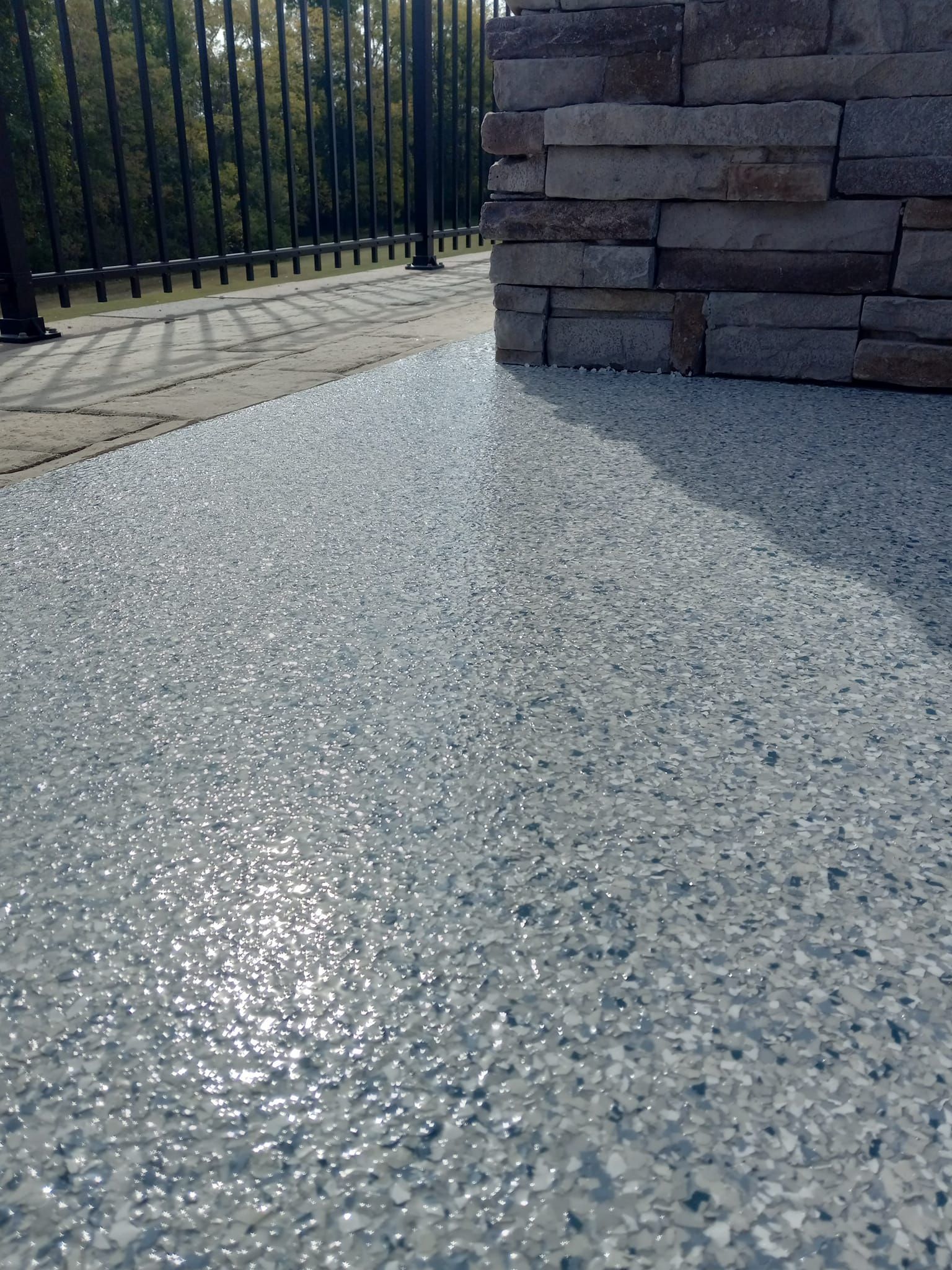 A close up of a concrete floor next to a stone wall.