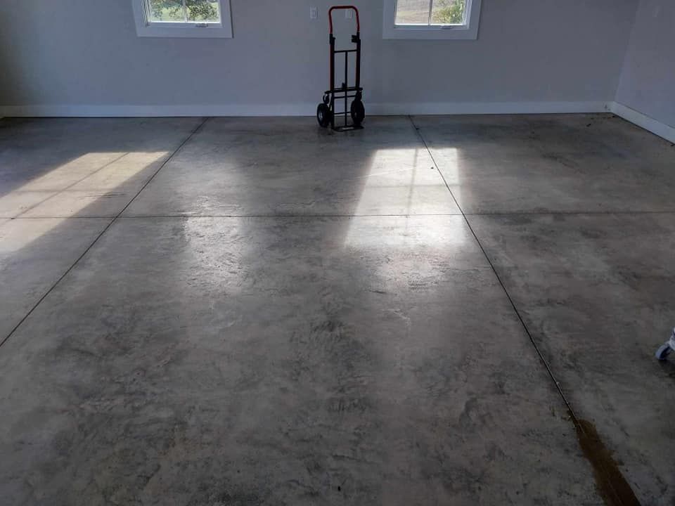 A concrete floor in a garage with a dolly on it.