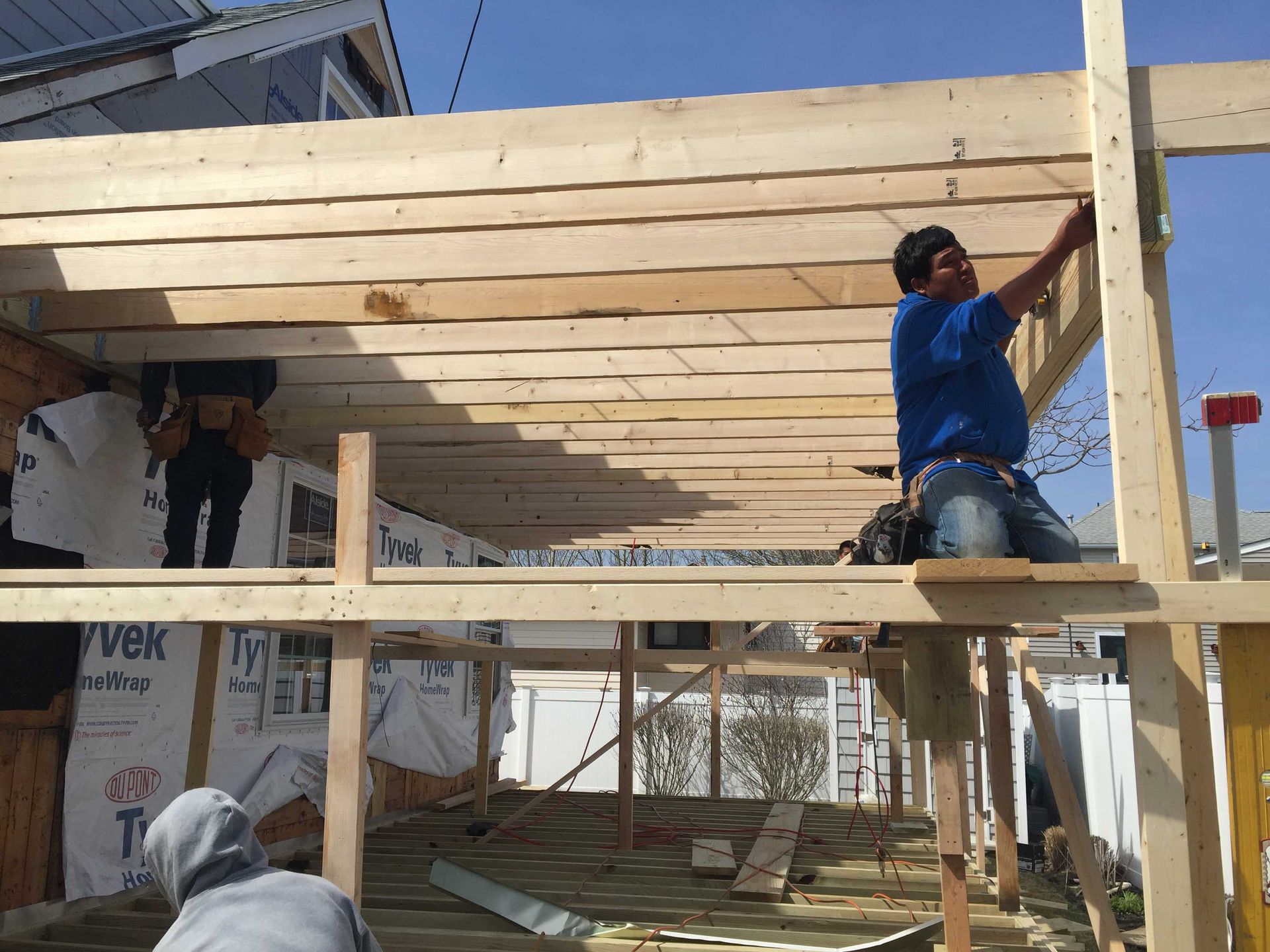 Workers installing wooden roof beams on a building under construction