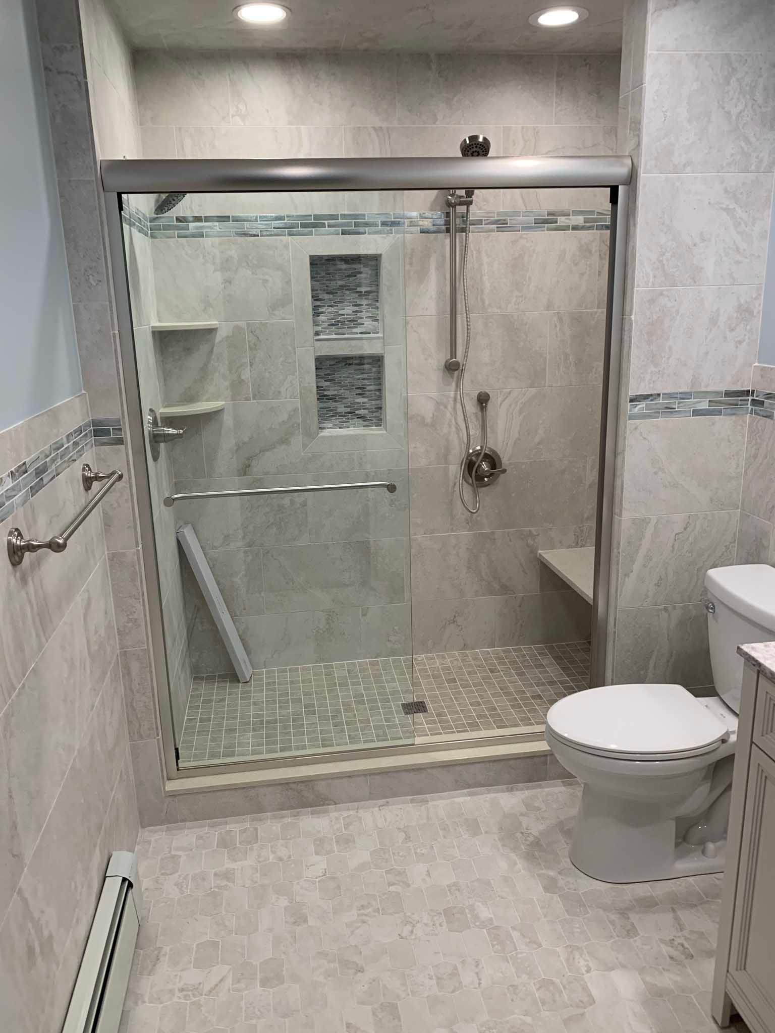 Accessible bathroom with roll-in shower, bench, grab bars, and toilet