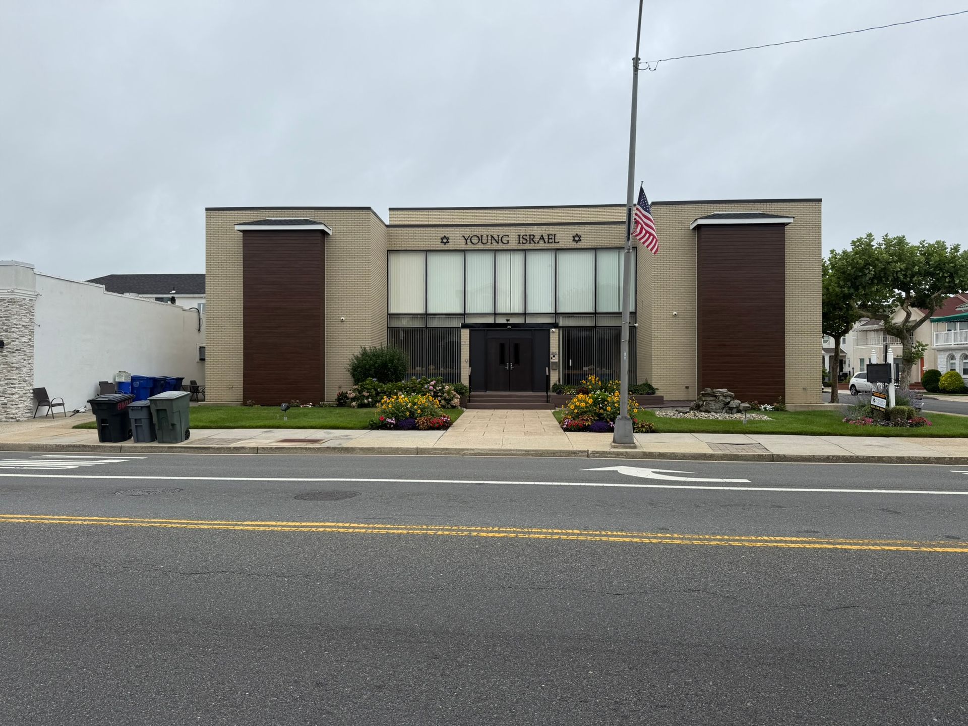 Commercial building with brick texture and wood accents with Young Israel sign.