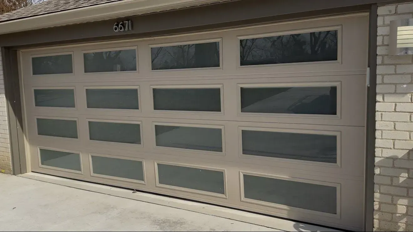Two-car garage with a brown paneled door and rectangular window panels