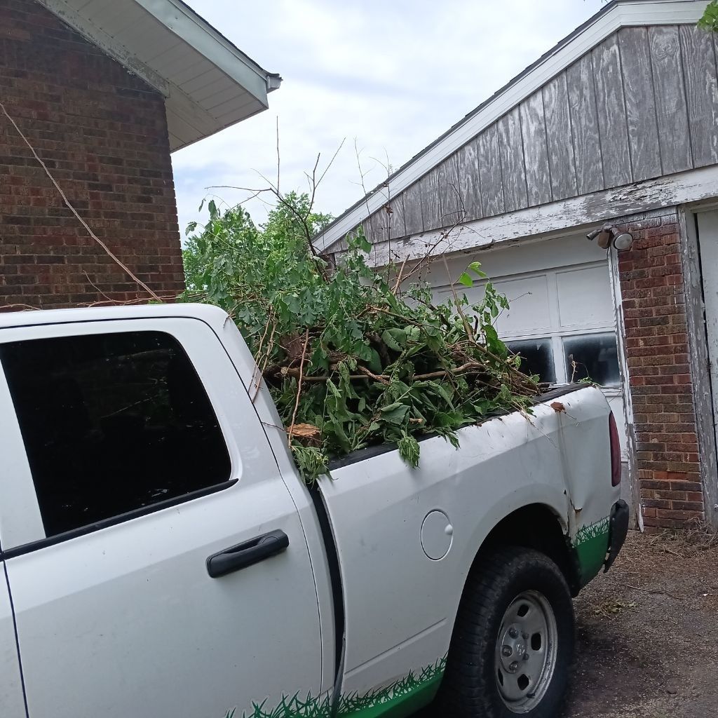 Hands wearing red gloves weeding a garden bed.