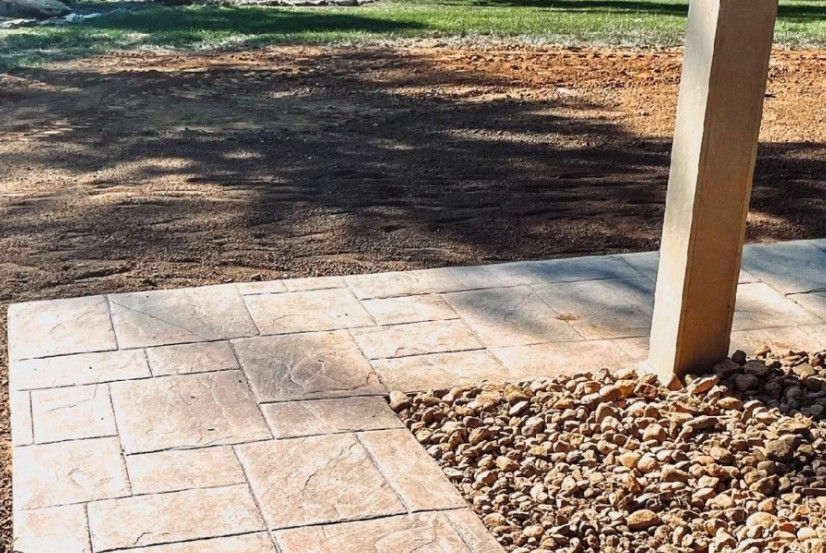 A concrete walkway with a wooden post in the background