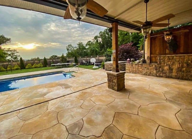 A patio with a ceiling fan and a pool in the background.