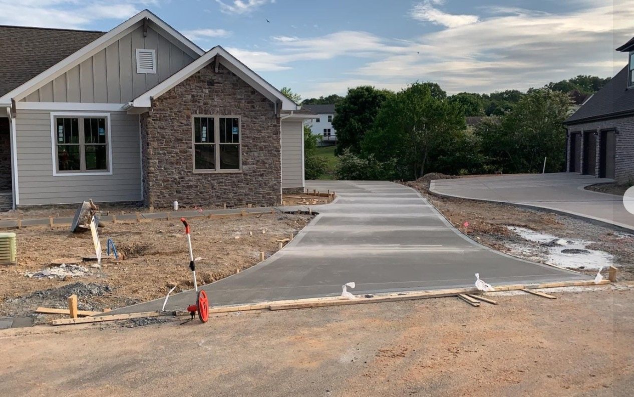 A concrete driveway is being built in front of a house.