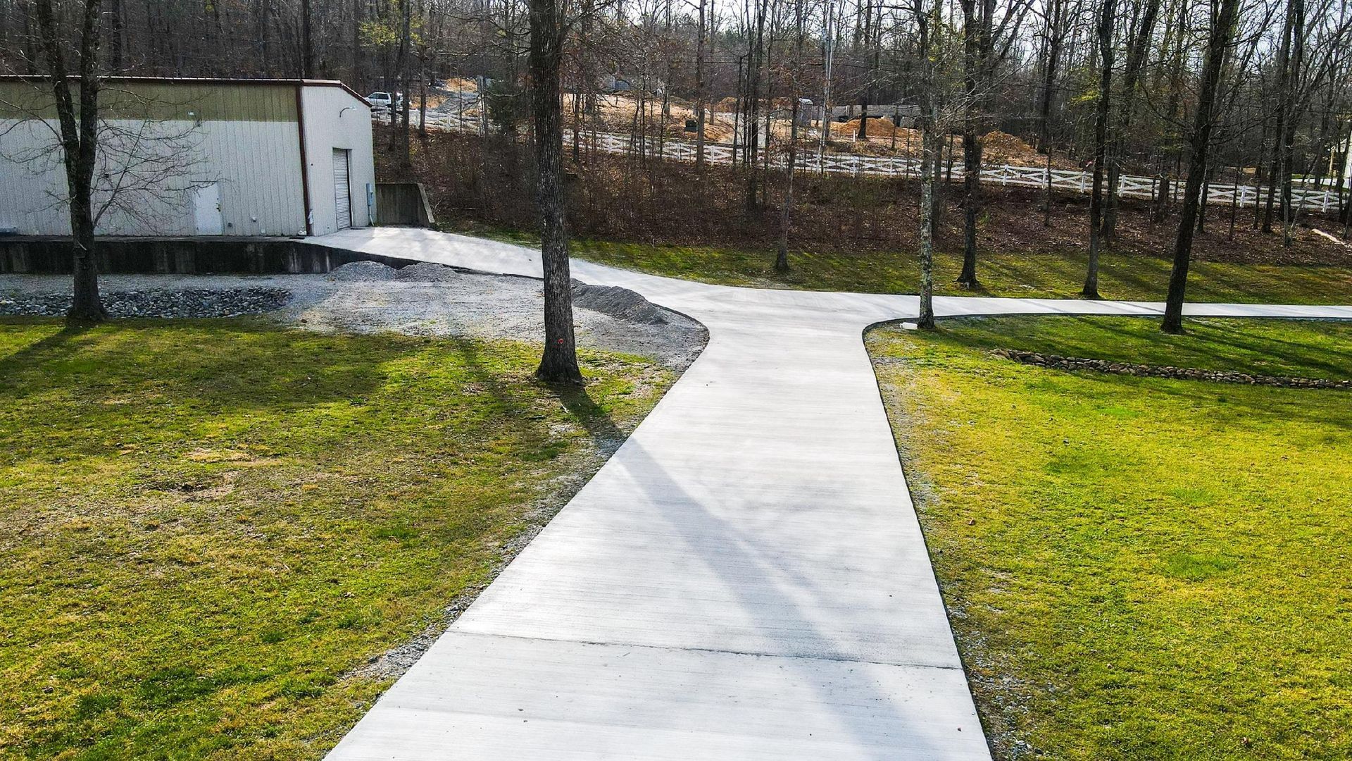 A concrete walkway leading to a building in a park.