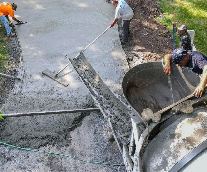 A group of men are working on a concrete driveway