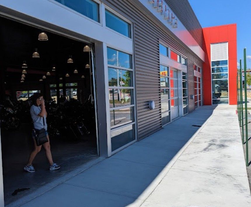 A woman is walking in front of a building with the door open