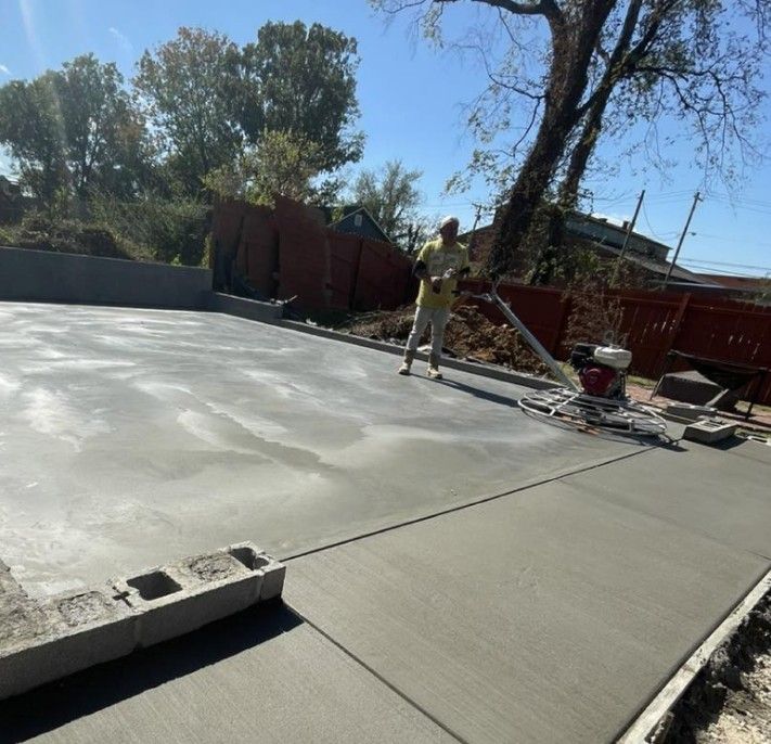 A man is standing in the middle of a concrete driveway