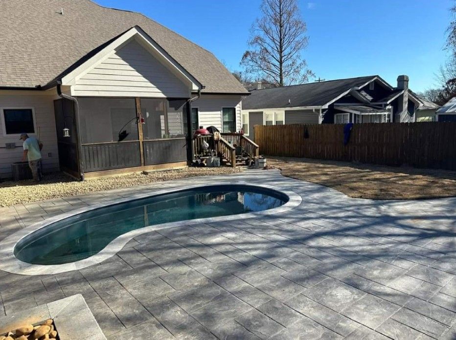 A large swimming pool is in the backyard of a house.