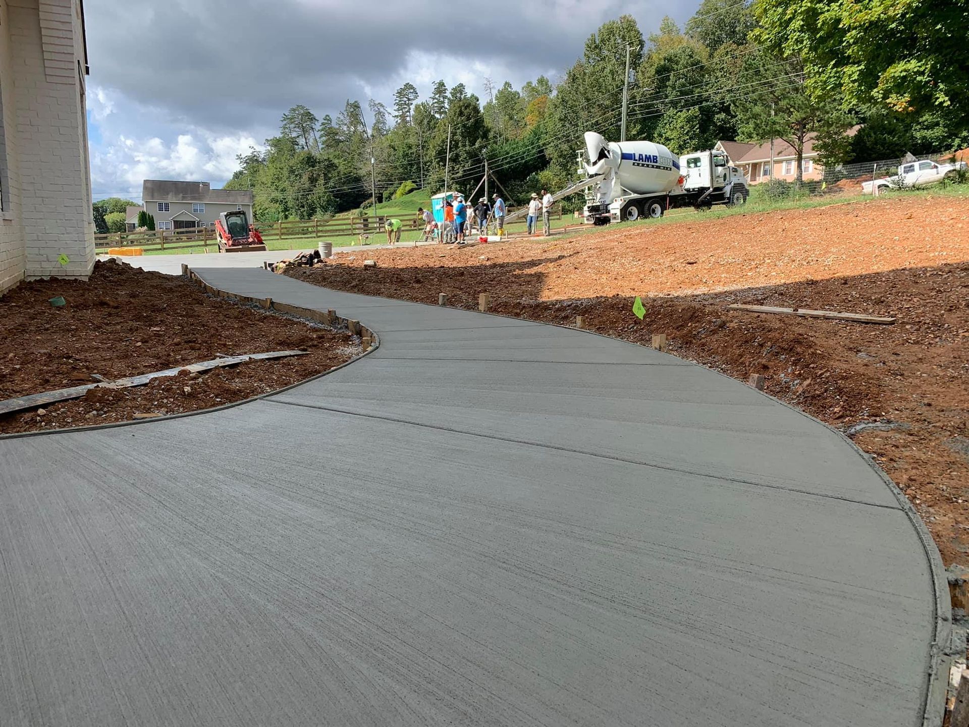 A concrete driveway is being built in front of a house.