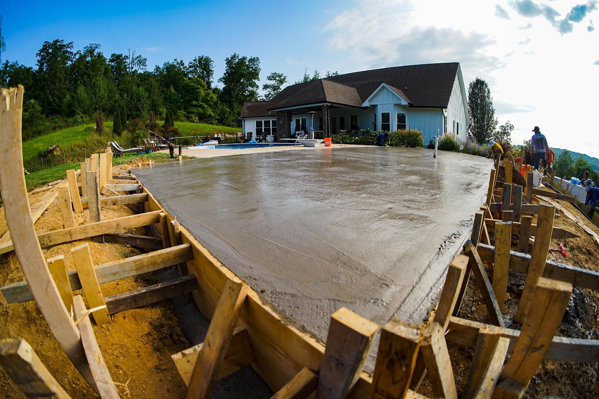 A concrete driveway is being built in front of a house