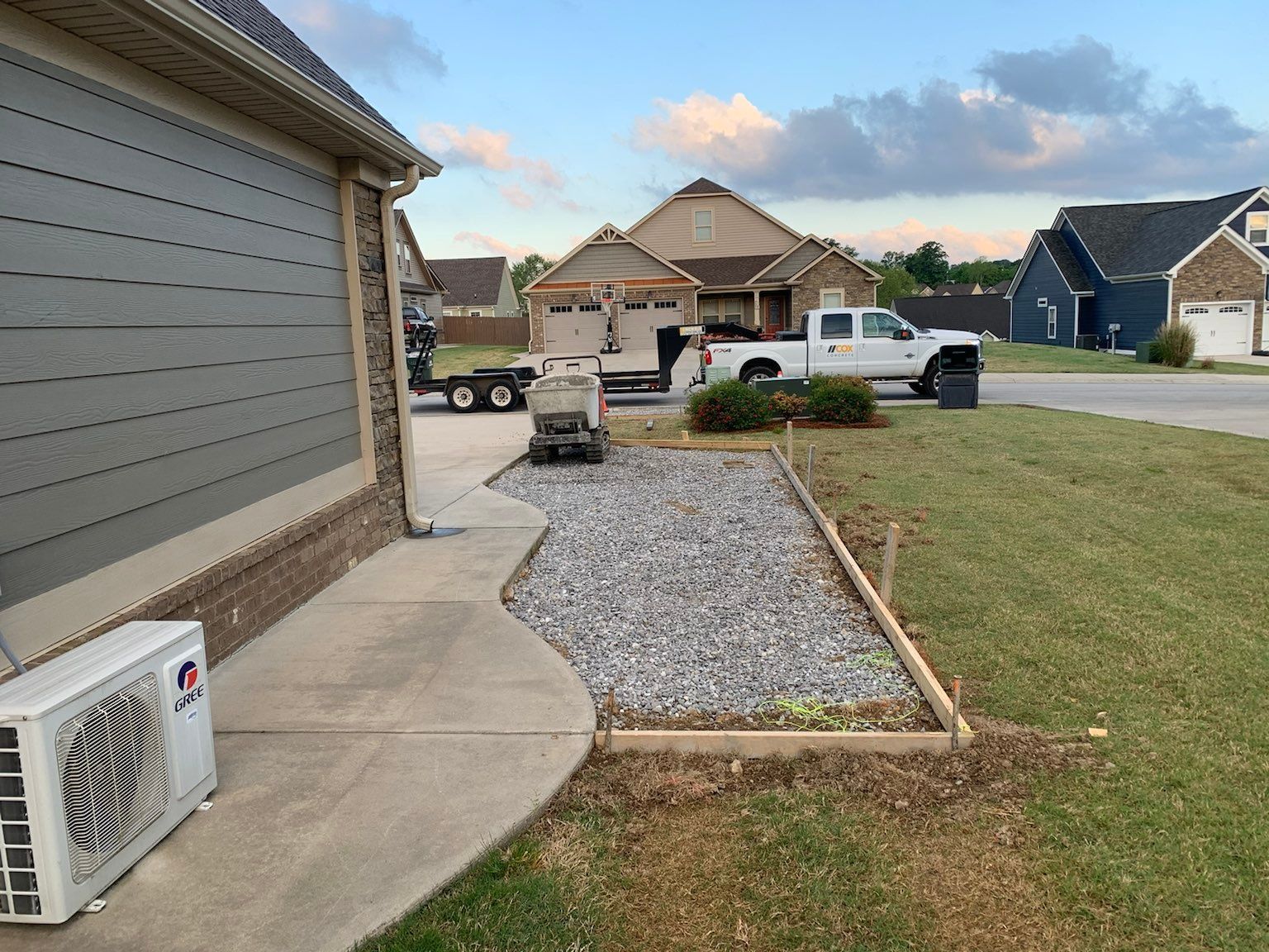 A white truck is parked in front of a house in a residential neighborhood.