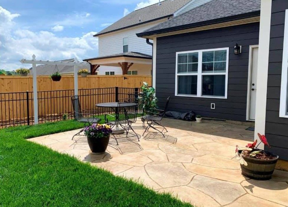 A patio with a table and chairs in front of a house.