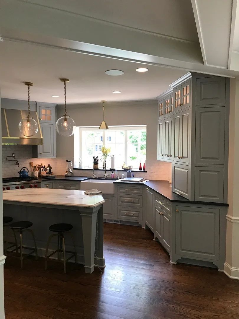 Gray and white kitchen with island, cabinets, and a window.