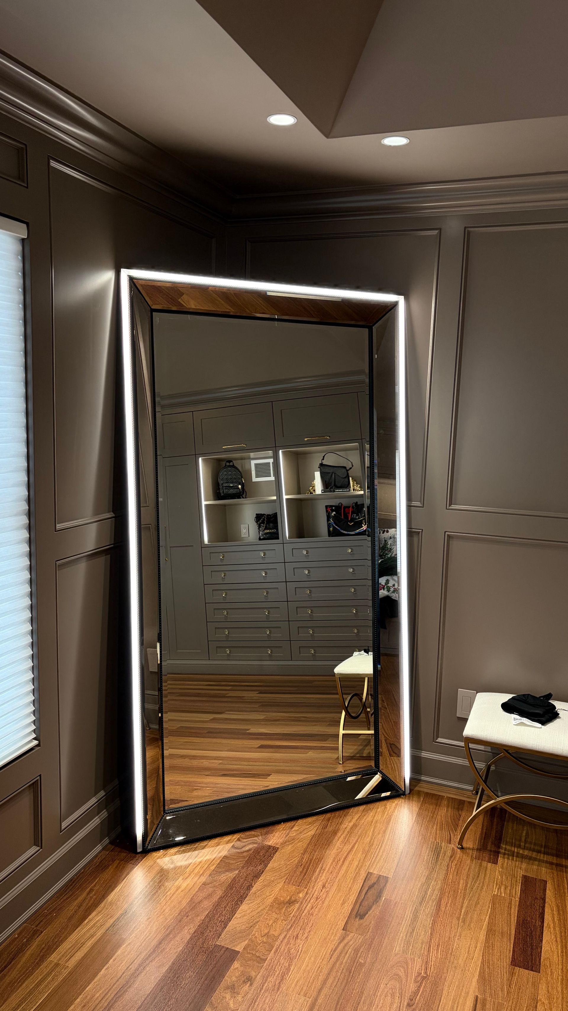 Full-length mirror with white LED lighting, in a room with wood floors and built-in closet.
