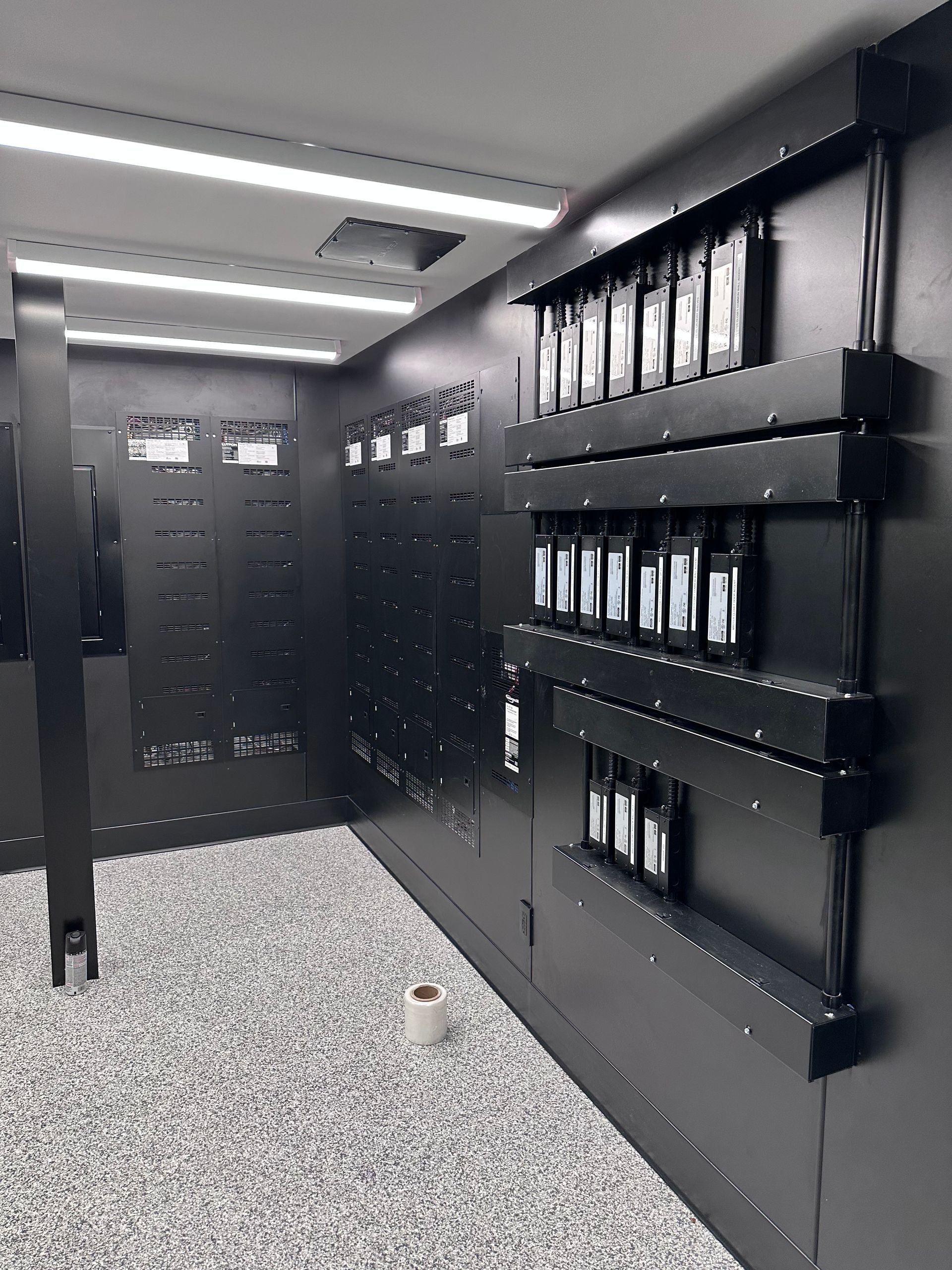 Dark interior with shelves displaying products. Walls are black, floor speckled gray.