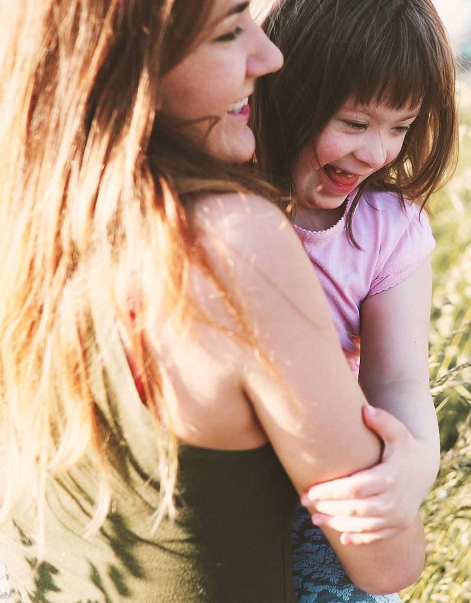 a woman is holding a little girl in her arms