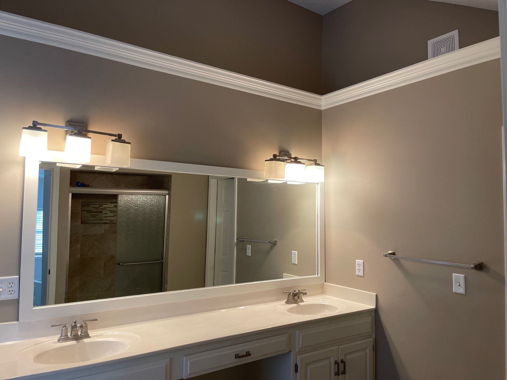 A bathroom with two sinks and a large mirror