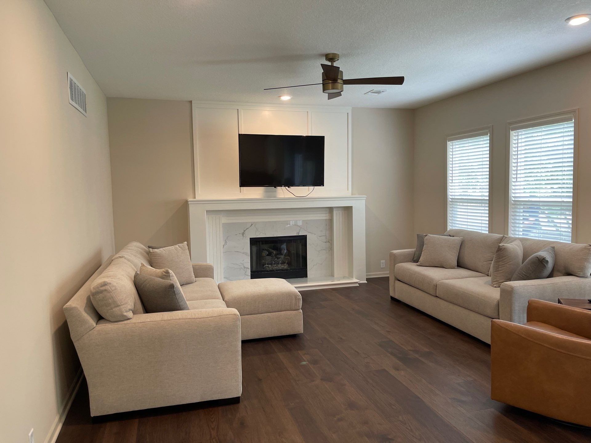 A living room with a couch , chair , fireplace and television.