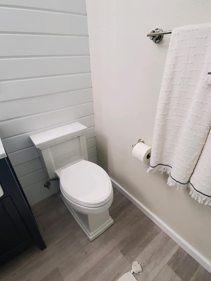 A bathroom with a toilet, sink, and towels.