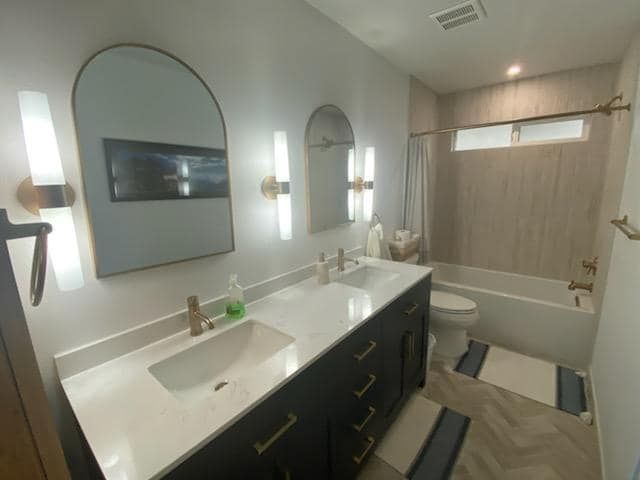 A bathroom with two sinks a toilet and a bathtub