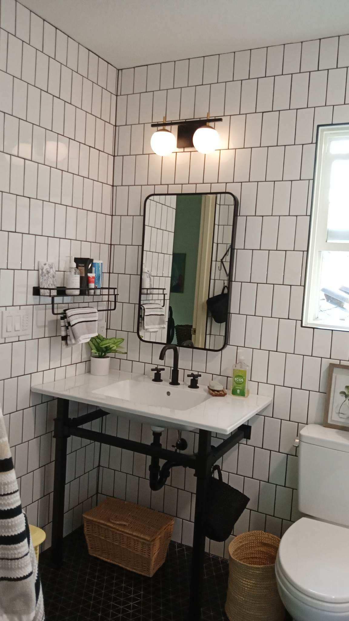 A bathroom with a sink, toilet and mirror.