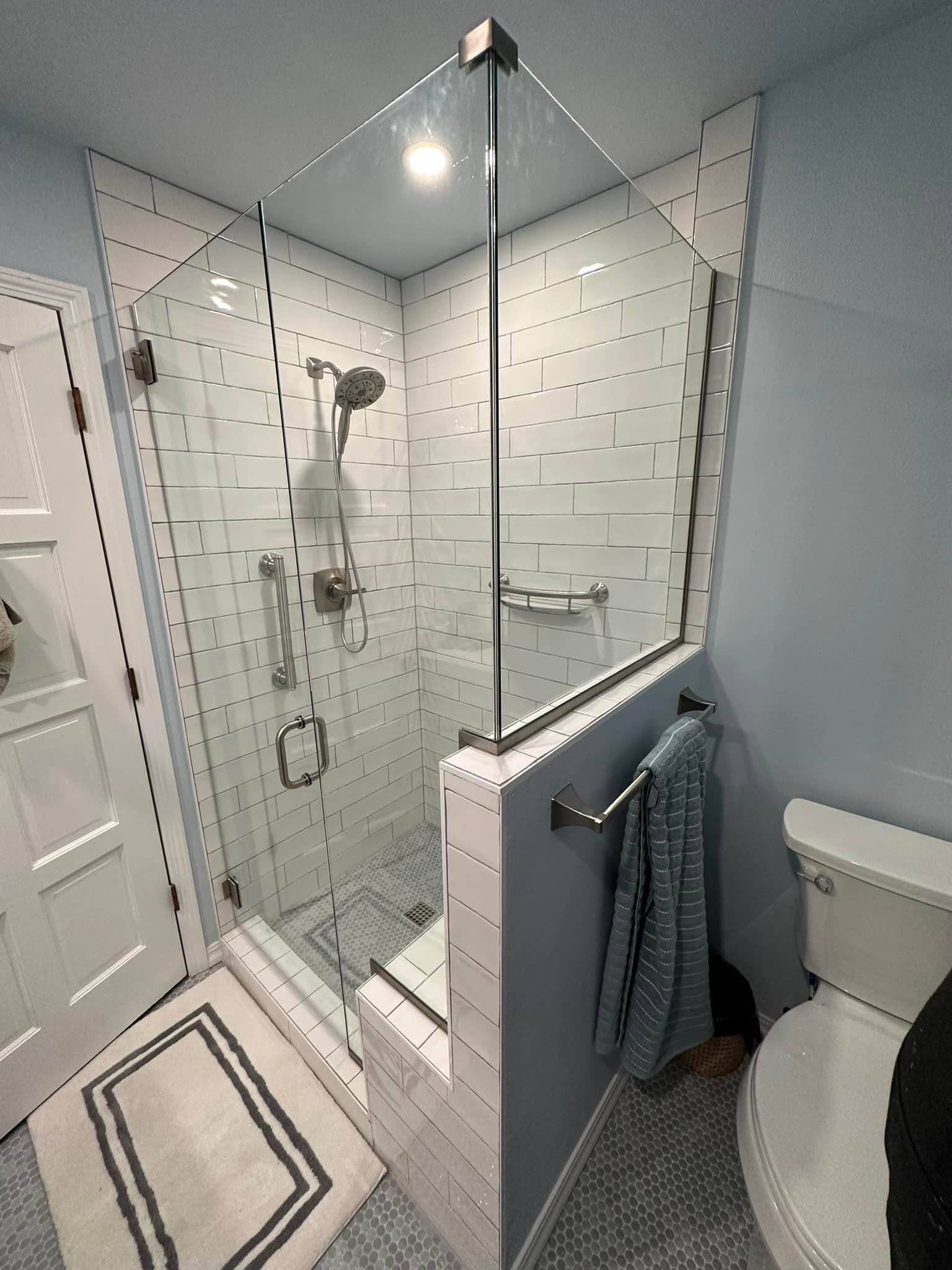 A bathroom with a toilet and a shower with a glass door.