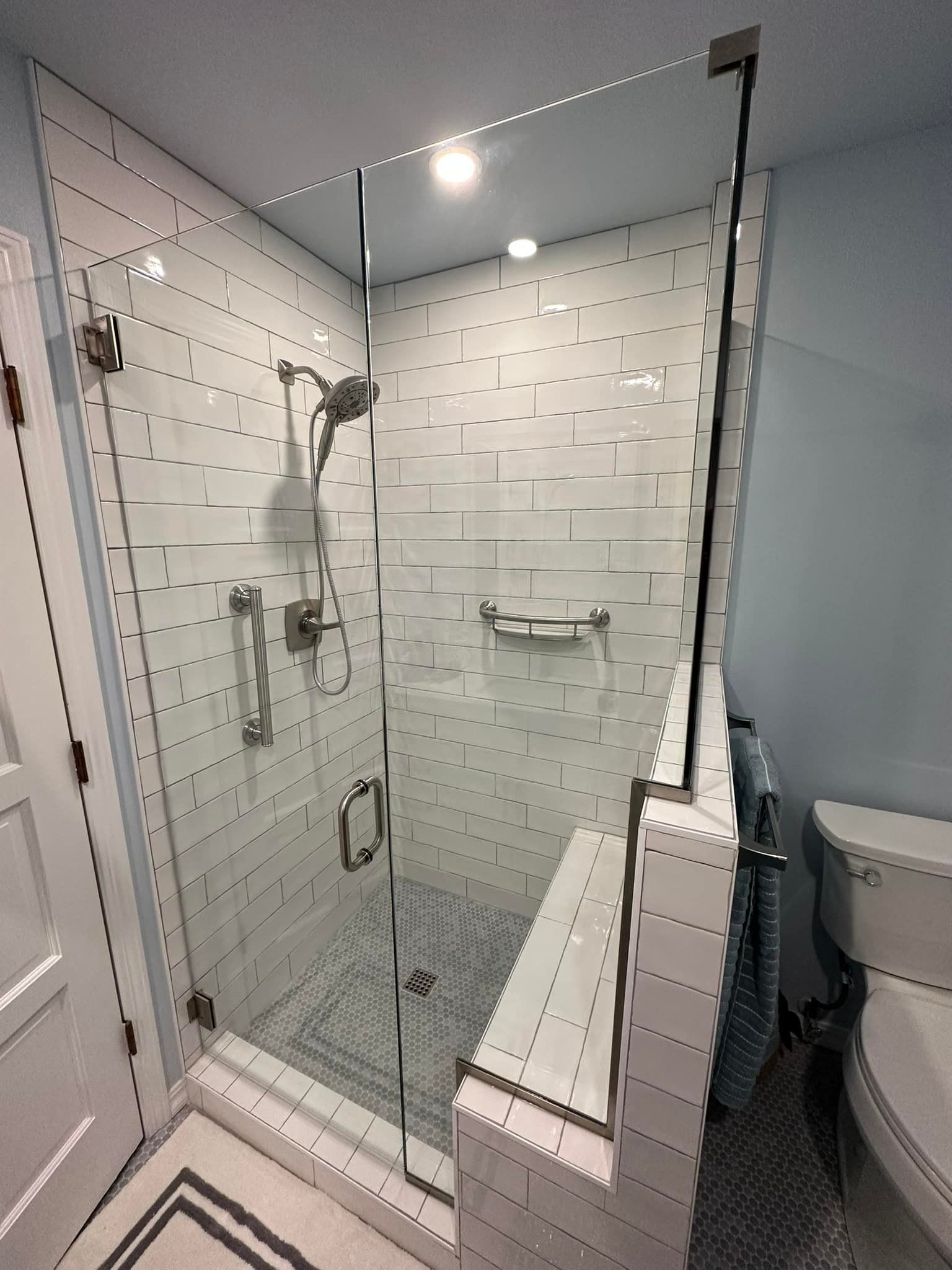 A bathroom with a walk in shower and a toilet.