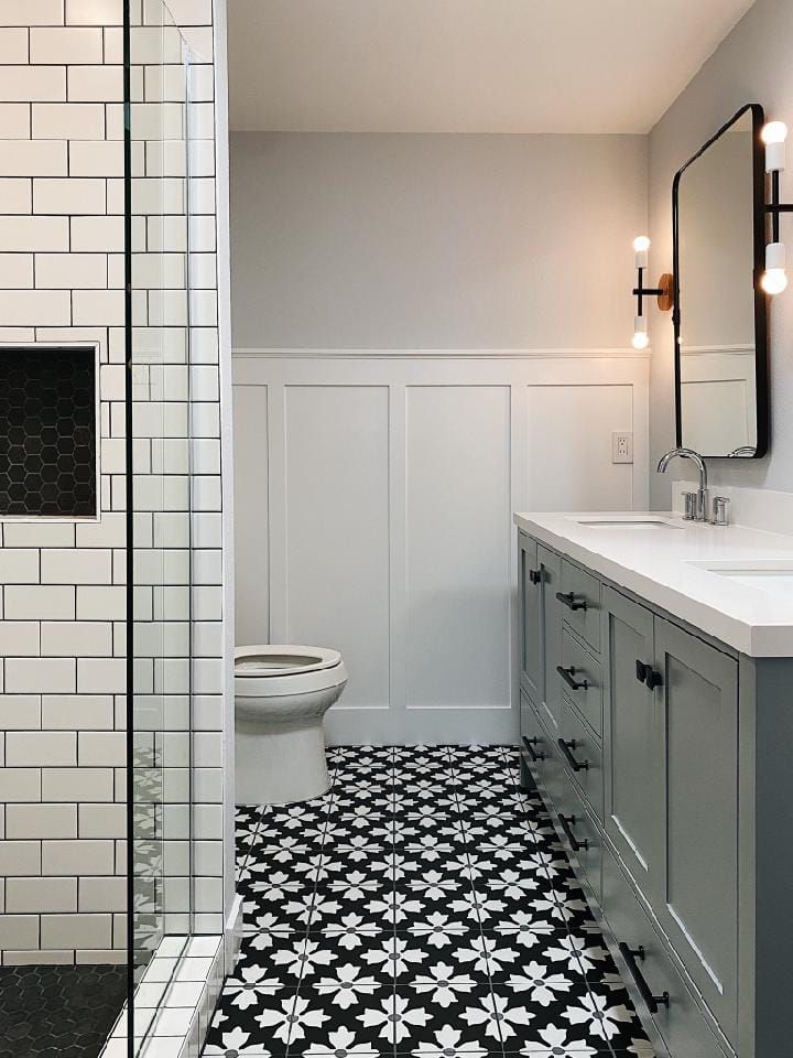 A bathroom with black and white tiles and a toilet