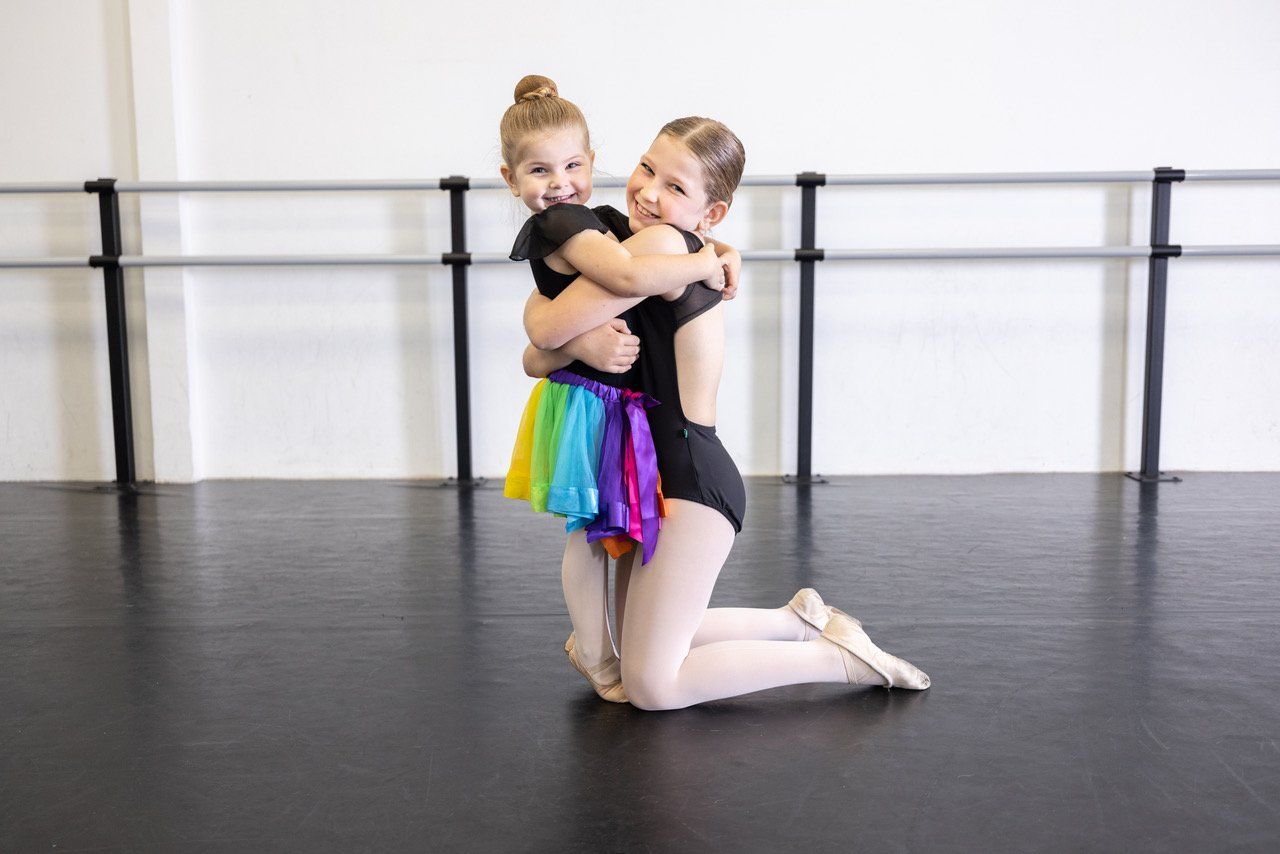 sister ballerinas hugging
