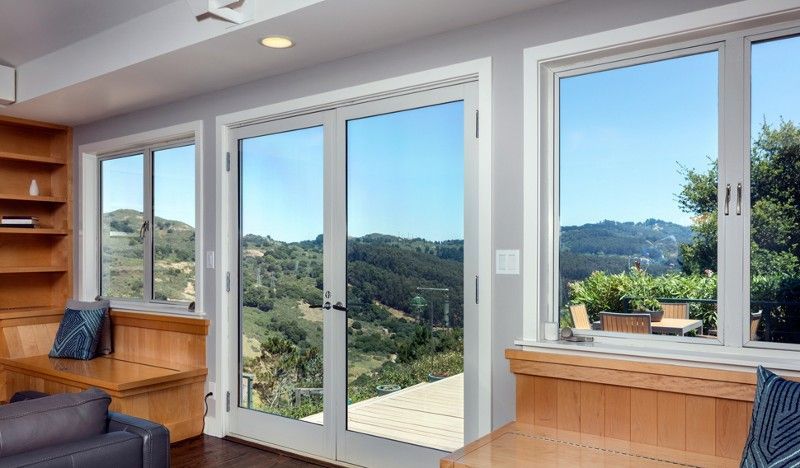 A living room with a lot of windows and a view of the mountains.