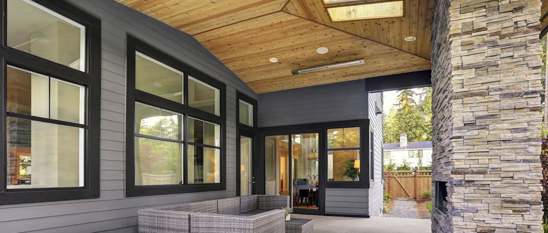 A large porch with a lot of windows and a fireplace.