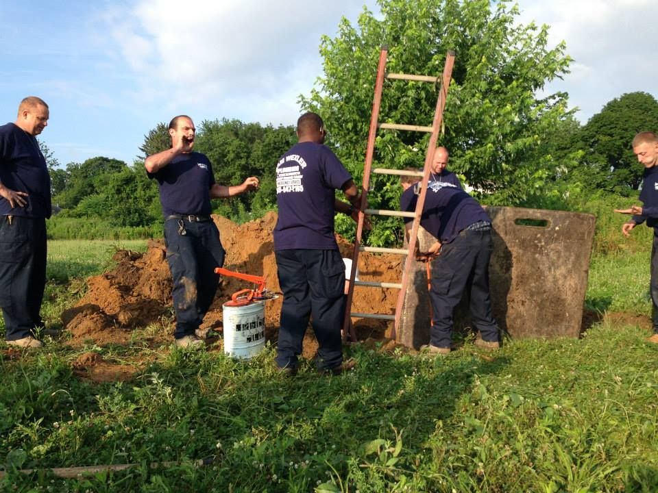A group of men are working in a field with a ladder