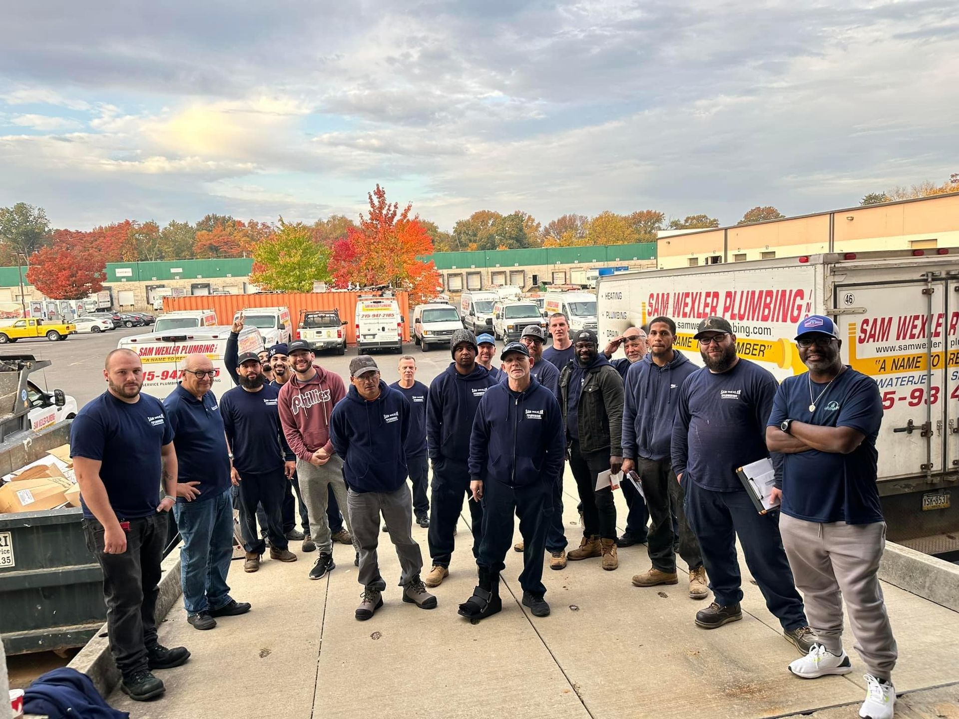 A group of men are standing in front of a white truck.