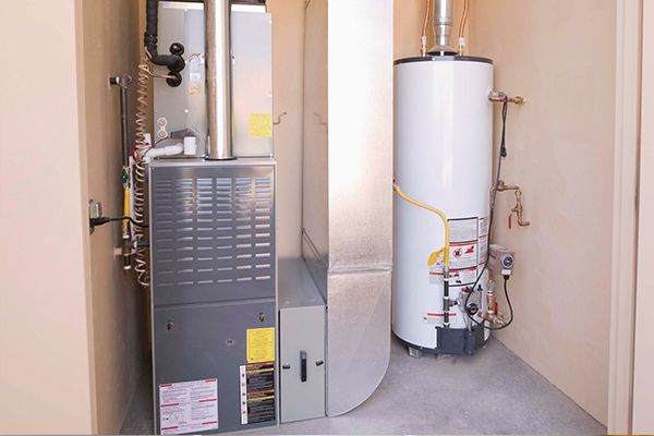 A room with a heater and a water heater in it.