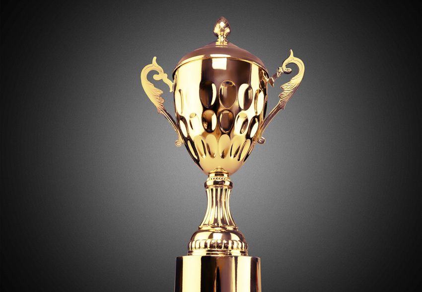Gold trophy on a pedestal, with a curved handle and lid, against a dark gray gradient background.