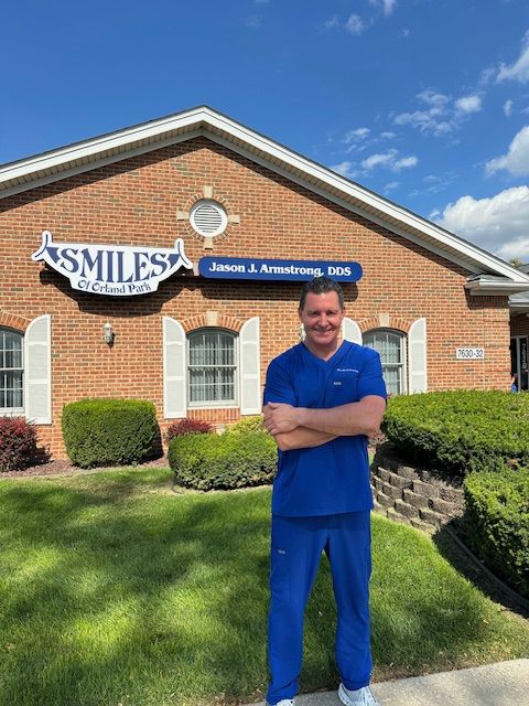 Man in blue scrubs stands in front of