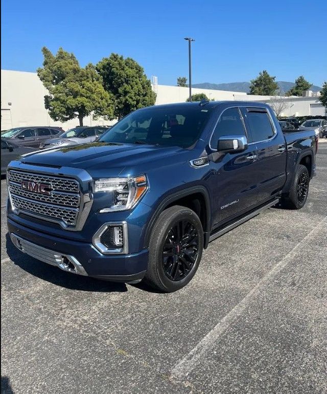 Blue GMC pickup truck parked in a lot on a sunny day