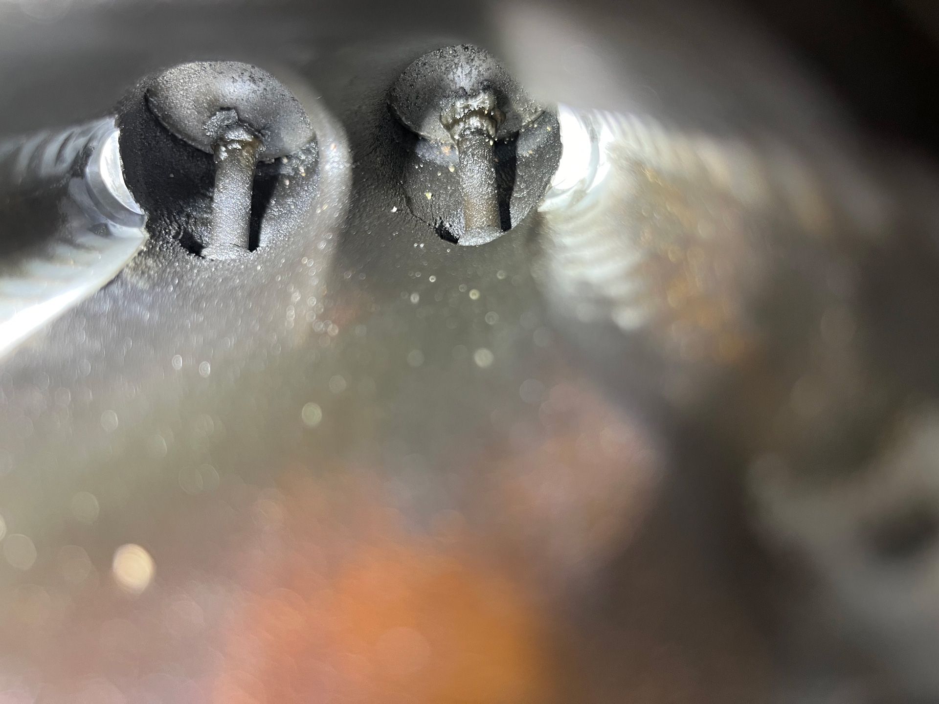 Close-up of two frosted glass light bulbs with reflective metallic surfaces.