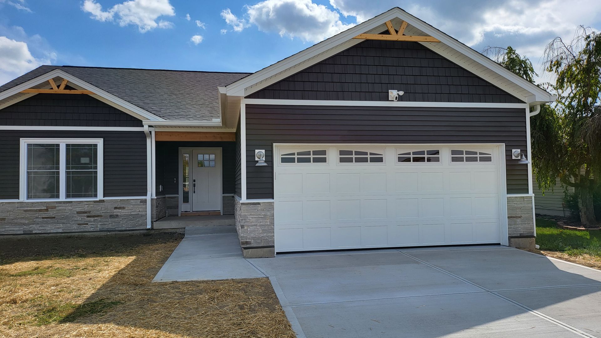 A house with a large garage door and a large driveway.